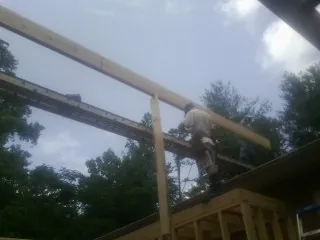 Carpenter setting a ridge beam over a new addition frame — Ice Dam Removal by Roofing Brothers in Rydal
