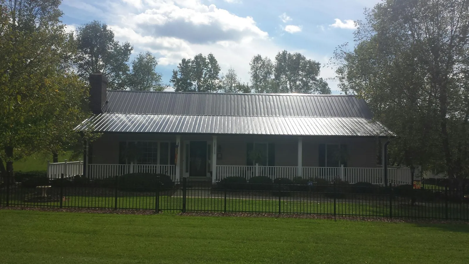 Gray metal roof on a brick ranch with a full width front porch — Gutter Guard Installation work by our crew in Rydal